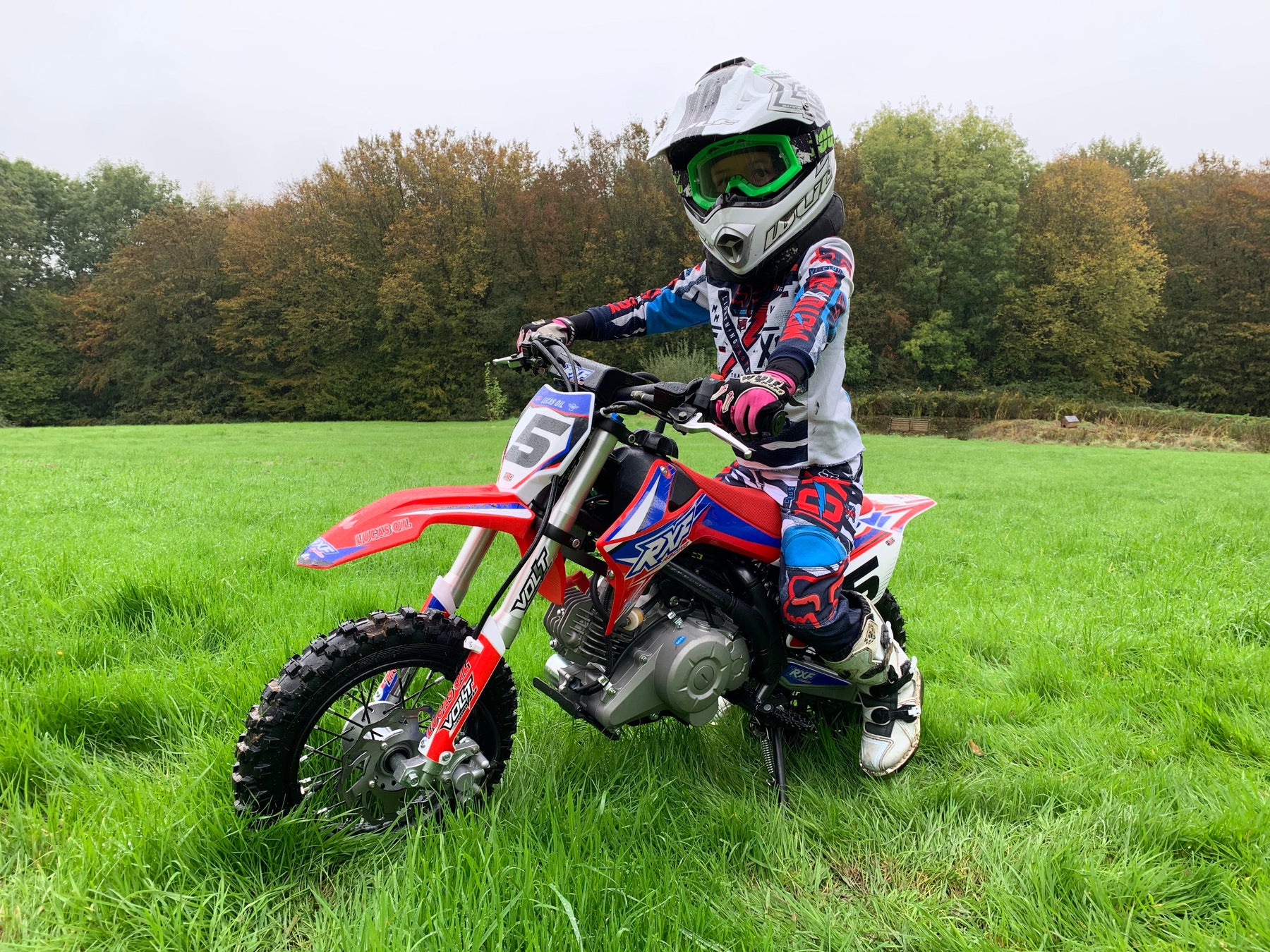 Boy aged 6 riding the RXF60cc Mini Dirt Bike on a field of grass