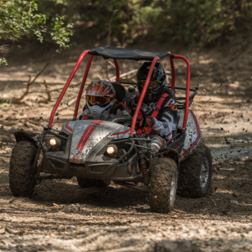 1 adult with a child, in a Hammerhead GTS150 buggy in action on the mud