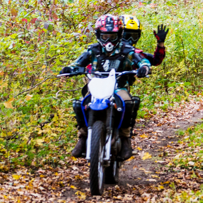 Two kids riding a dirt bike