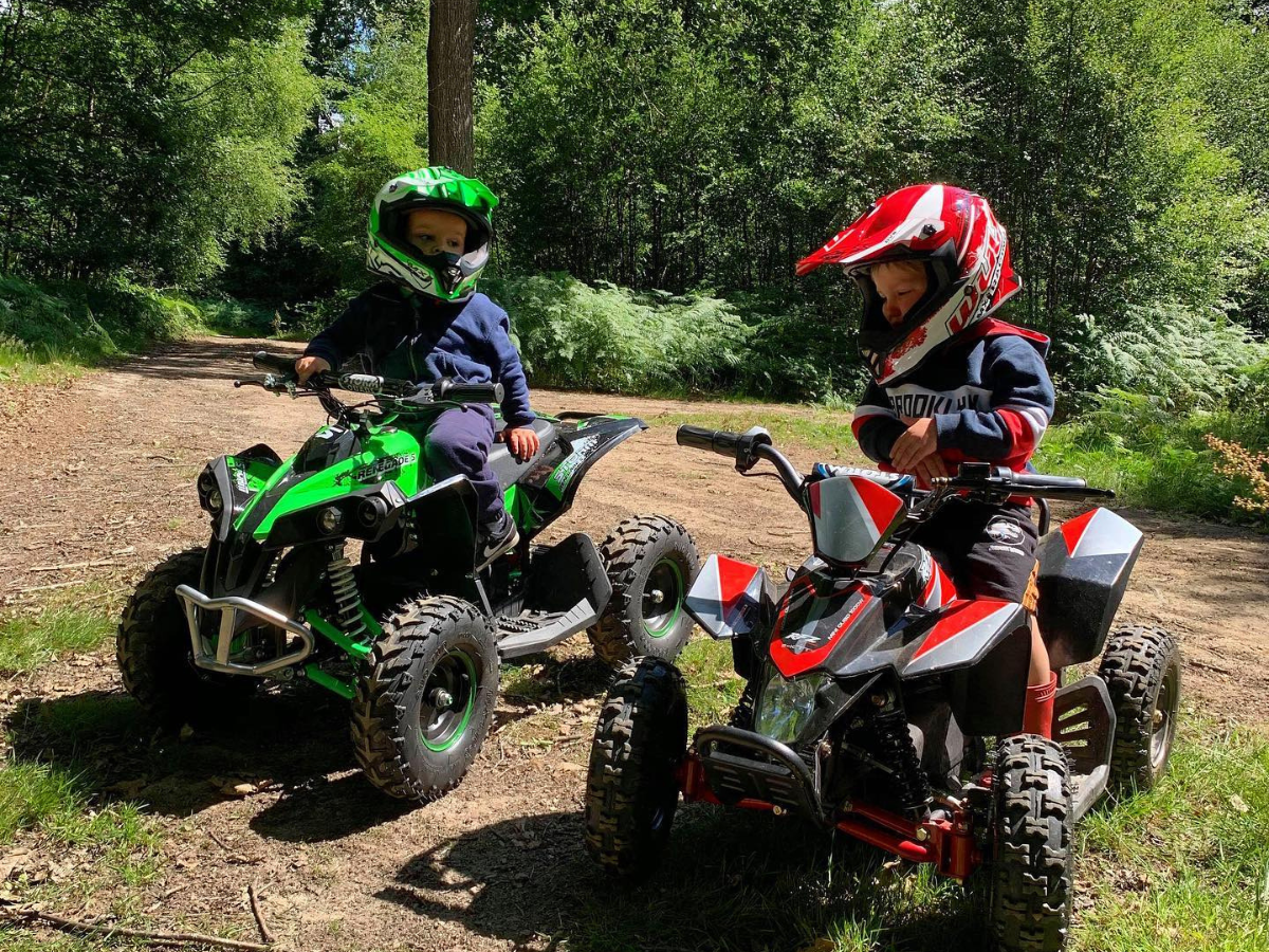 Two children sitting on electric quad bikes